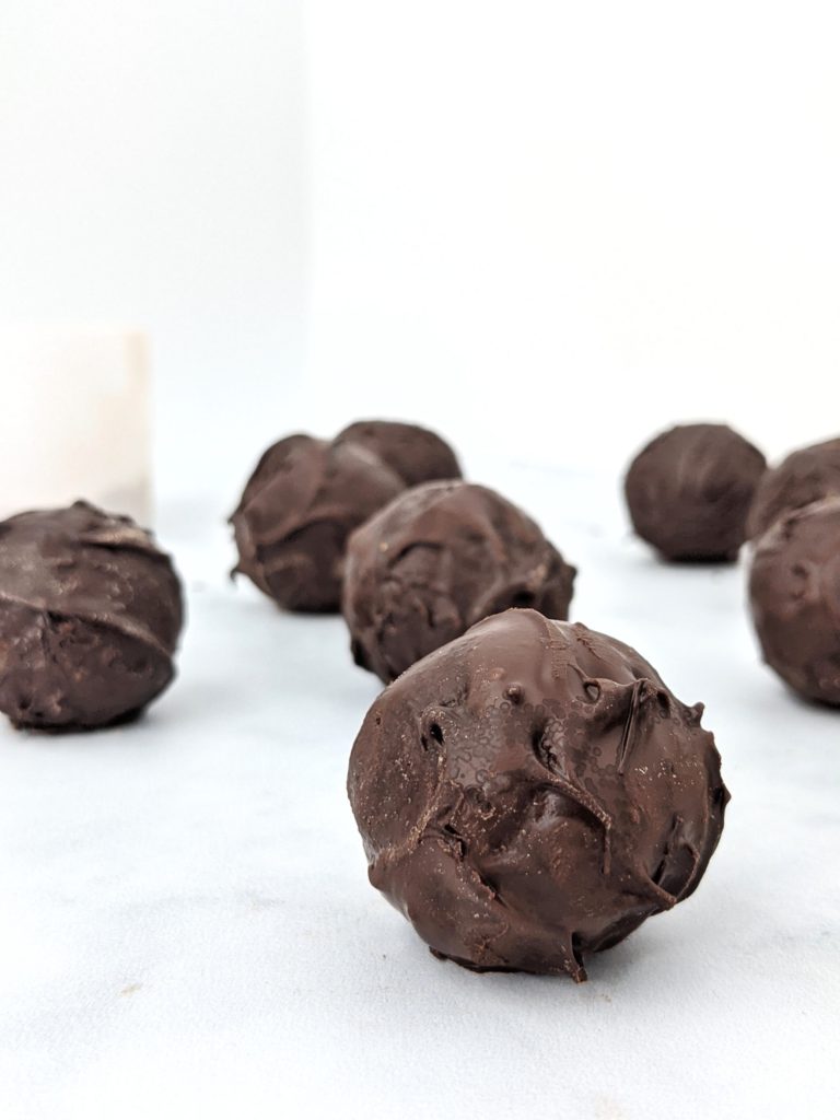 5 Ingredient Chocolate Protein Truffles made with oat flour, cacao powder, protein powder and milk, and dipped in melted chocolate; These no bake protein truffles taste just like brownie balls, and are great for a snack, dessert, or high protein post workout treat!