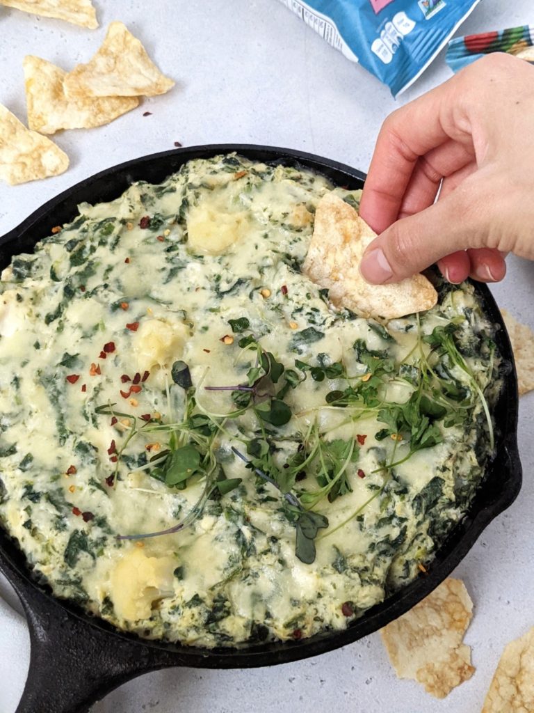 A delicious and easy baked Cauliflower Spinach Cheese Dip made with low fat cream cheese, mozzarella and parmesan, sure to be your new chip & dip go-to. Loaded with nutrition from the cauliflower and spinach, this healthy dip also has Greek Yogurt and no cream!