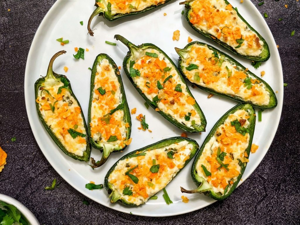 Easy and light Baked Jalapeno Poppers stuffed with cream cheese and cheddar, baked in the oven, and topped with chips! Crispy, creamy and cheesy perfection!