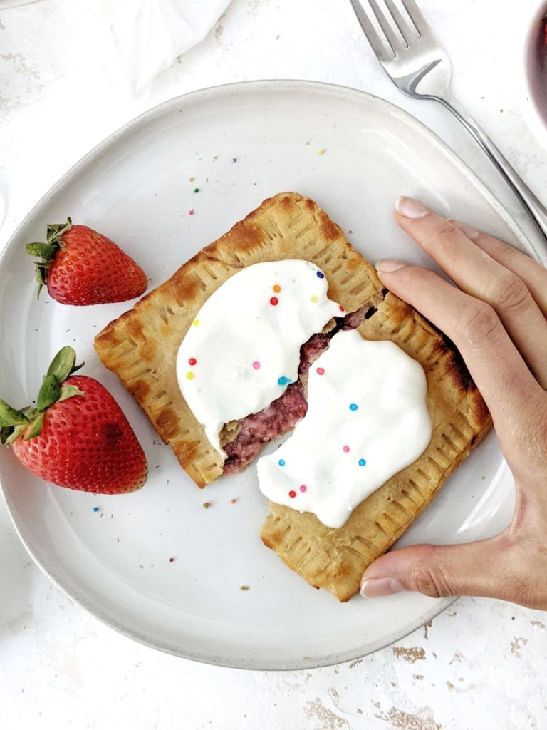 A big single serve Healthy Protein Pop Tarts made with a gluten free base, filled with homemade strawberry jam and topped with high protein sugar free frosting; Vegan too. An easy protein powder poptart made in the air fryer - or baked - to satisfy the sugar cravings.