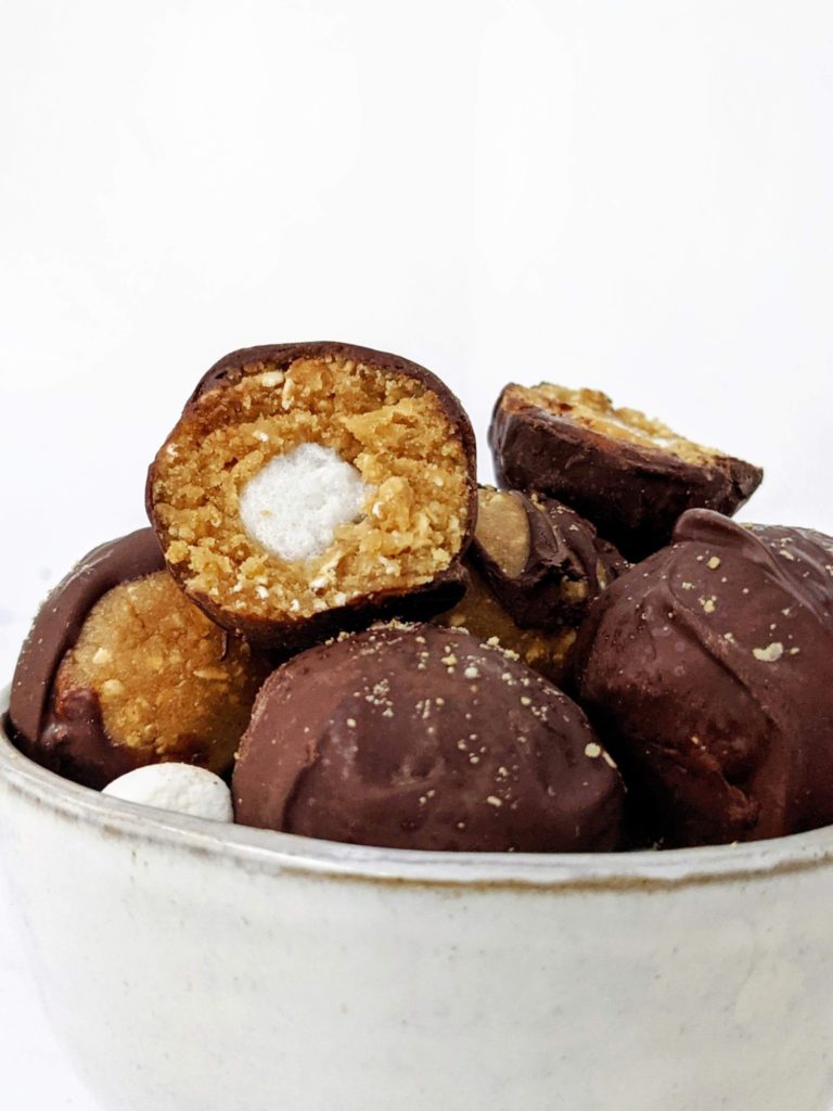 These S’mores Protein Balls are made with graham crackers and marshmallows like a real s'mores desserts, but made healthy with protein powder, collagen and oats! S’mores protein bites are perfect for a snack, dessert or midday energy boost.