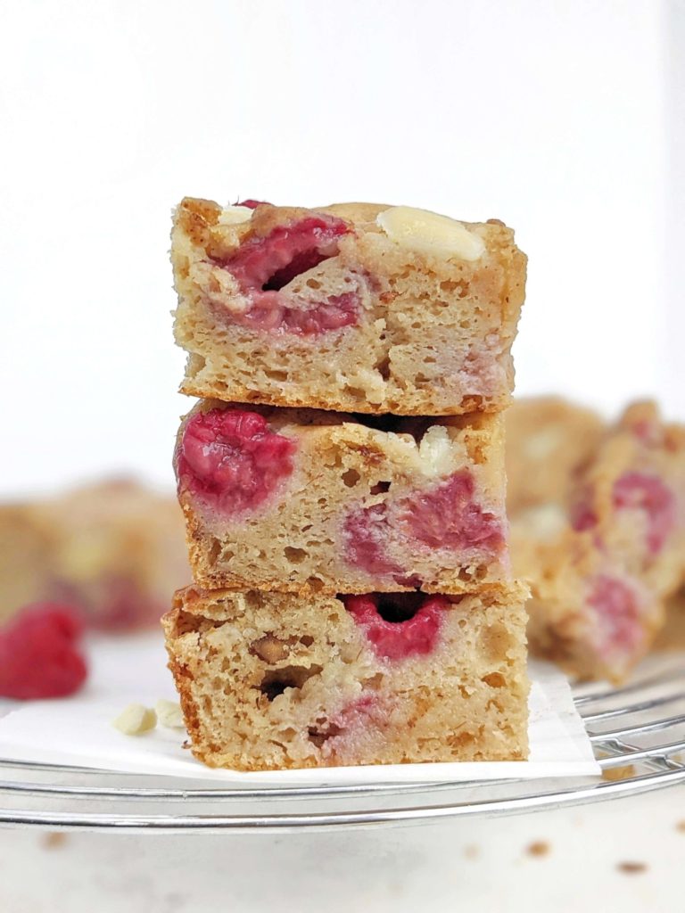 Beautiful White Chocolate Raspberry Protein Blondies make the perfect high protein raspberry dessert for summer! Healthy raspberry blondies use protein powder for sweetener, sugar free white chocolate, and a bit of almond butter, for a low calorie and Vegan raspberry blondie recipe!