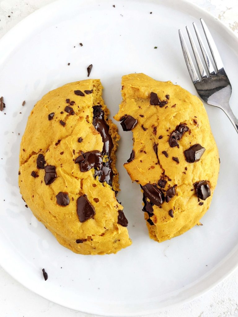 A ginormous Chocolate Lava Pumpkin Protein Cookie for One with a gooey molten chocolate center. This healthy single serve pumpkin protein powder cookie is gluten free, vegan and sugar free; A perfect pumpkin protein dessert.