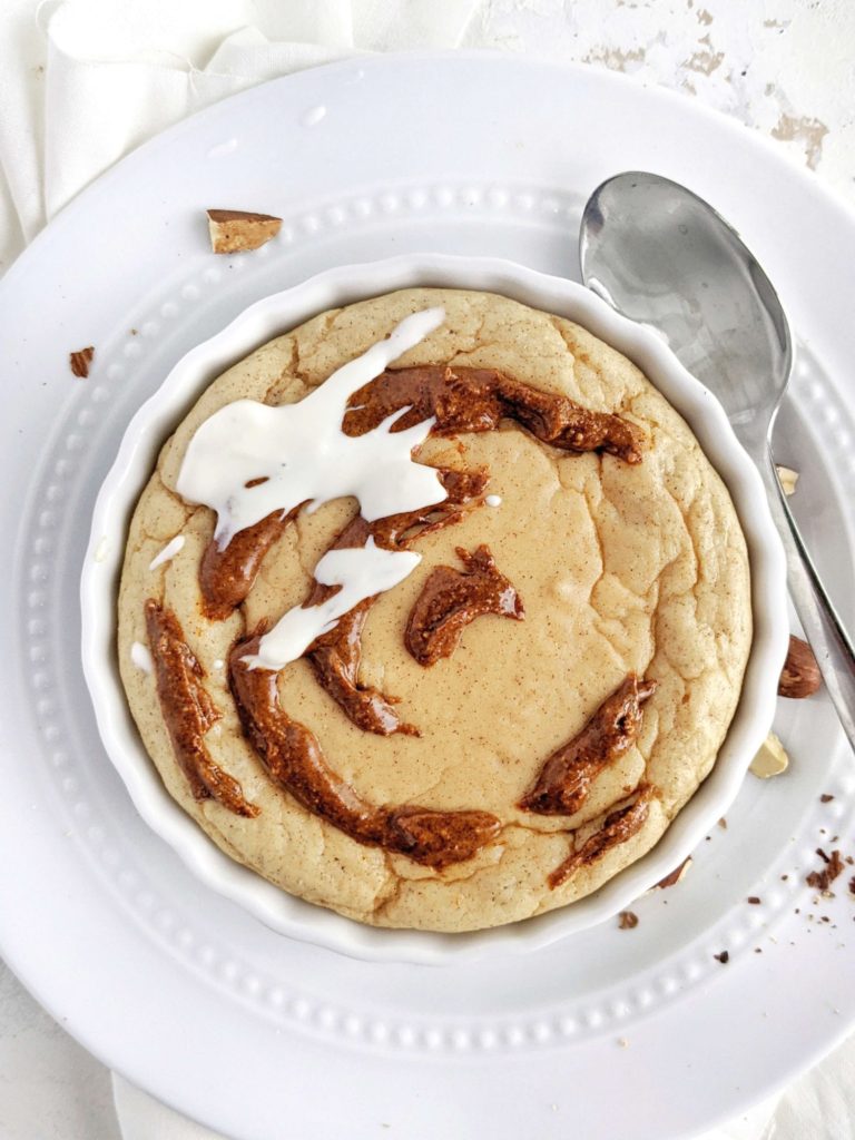 A pretty and pretty Fudgy Cinnamon Protein Mug Cake complete with a swirl and icing. This healthy cinnamon roll protein mug cake uses protein powder, and has no flour or sugar - an easy and keto friendly dessert!