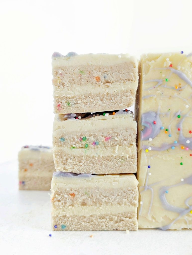 Just superb Birthday Cake Protein Bars recipe complete with no bake protein cake base and protein frosting layers! These funfetti protein bars are low fat, low calorie, sugar free, gluten free and have a Vegan option too. A real celebration cake batter bar!