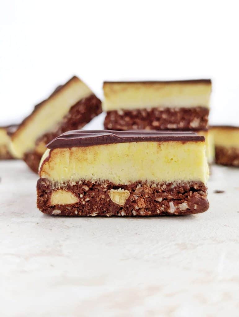 Beautiful Protein Nanaimo Bars with layers of a protein chocolate-coconut, protein powder custard and melted chocolate. These healthy, homemade Nanaimo bars are a perfect low calorie, Vegan, gluten free and sugar free alternative to the popular Canadian treat.