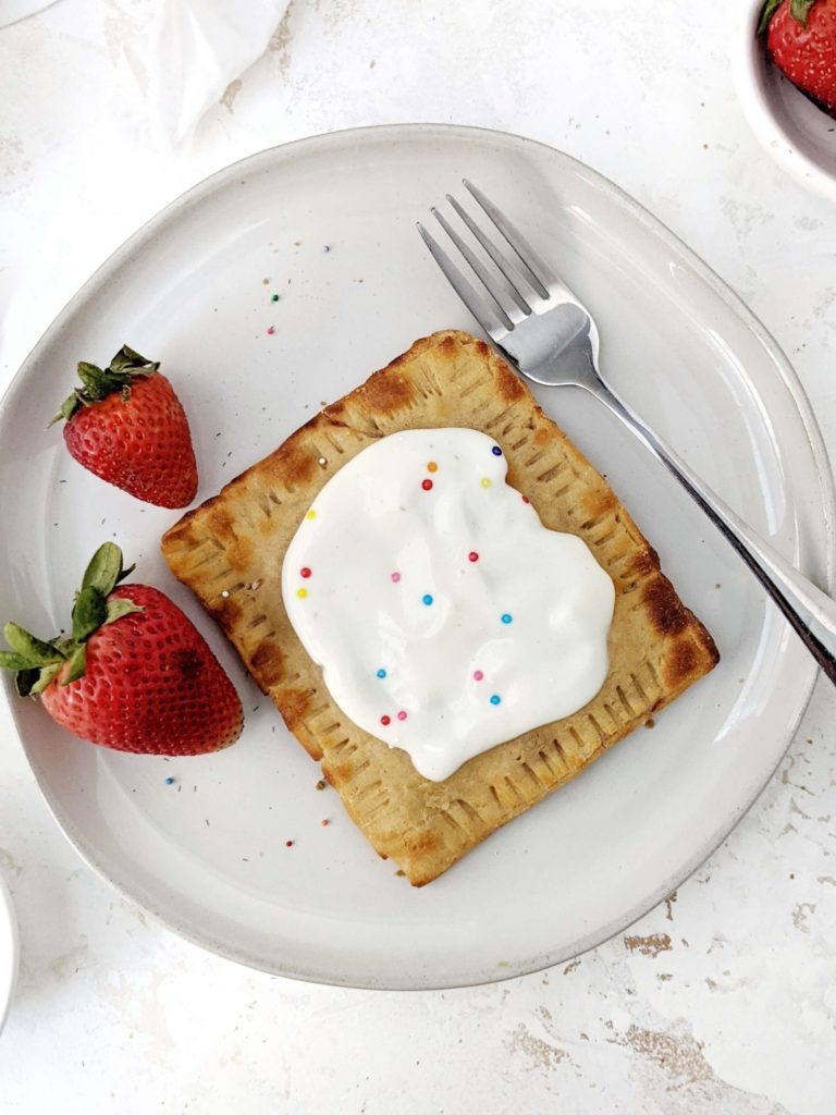 A big single serve Healthy Protein Pop Tarts made with a gluten free base, filled with homemade strawberry jam and topped with high protein sugar free frosting; Vegan too. An easy protein powder poptart made in the air fryer - or baked - to satisfy the sugar cravings.