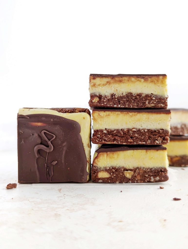 Beautiful Protein Nanaimo Bars with layers of a protein chocolate-coconut, protein powder custard and melted chocolate. These healthy, homemade Nanaimo bars are a perfect low calorie, Vegan, gluten free and sugar free alternative to the popular Canadian treat.